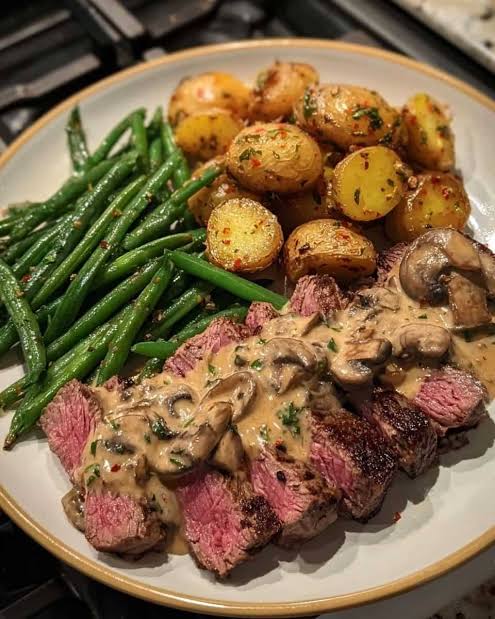 Steak with mushroom sauce, roast potatoes & greens
